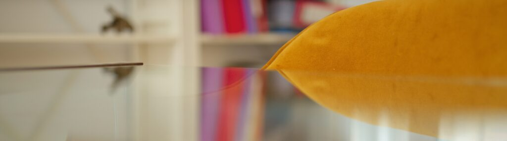 Table en verre du bureau d'Armand Feste-Guidon, avocat en droit pénal - Paris, Marseille, bibliothèque en arrière plan et dossiers multicolores